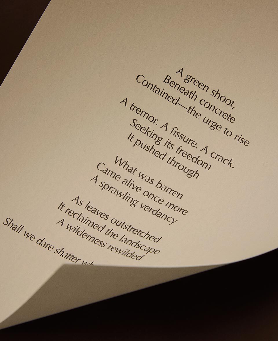 Gros plan d’une page de papier creme, avec des vers de poesie et un bord delicatement recourbe.